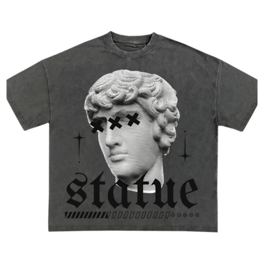 A dark gray short-sleeve t-shirt with a graphic print of a classical statue head with black 'X' eyes, the word 'statue' in a gothic font, and small star accents, shown on a plain white background.
